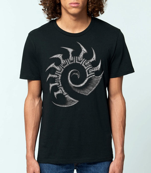 A man wearing a black short-sleeve t-shirt with a large grey stylized zerg starcraft logo on the chest, paired with blue jeans, against a light gray background.